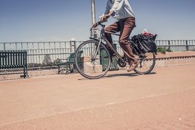 Man riding on bicycle along fence