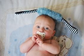 baby with dummy on a blanket