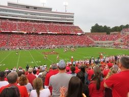 People in red and white clothing at the stadium