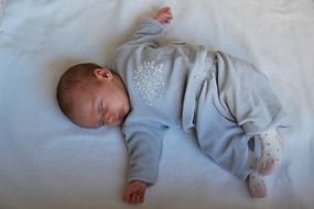 little baby sleeping on a white bed