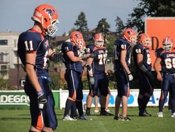 strong men in blue uniform play American football