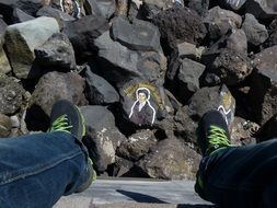feet dangle and portrait on stone