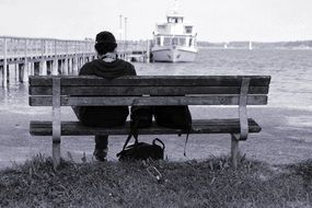 lonely man on a bench against the backdrop of the pier