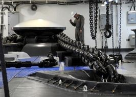man inspecting anchor chain on ship