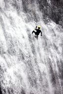 rappelling, man holding rope in waterfall