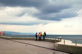 people on the quay under the thunderclouds