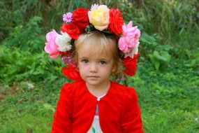 little blond girl with a wreath of large flowers on her head