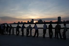 crowd of people on the waterfront at sunset