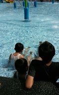 family with children is relaxing by the pool
