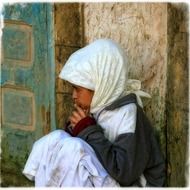 sad child girl sits at wall, morocco