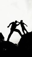 silhouette of father and child on the rock