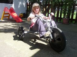 Picture of child is riding tricycle