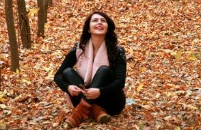 happy girl in the autumn park on a background of yellow leaves