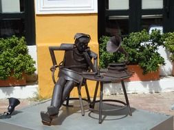 man listening to a gramophone, an iron statue
