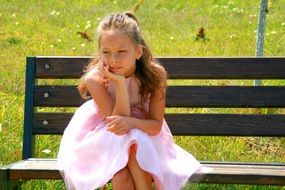 Girlie in a dress sitting on a bench