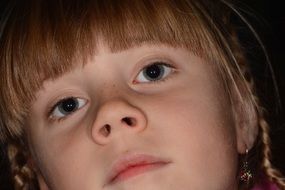 face of a little girl with open eyes close-up