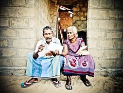 senior husband and wife with papers in hands sitting at door