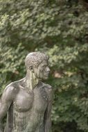 man sculpture statue green trees aback