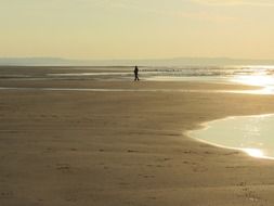 man walking by beach at evening, france, pas de calais