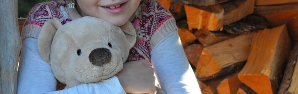 child with teddy bear soft toy