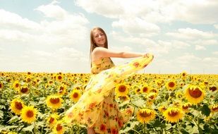 Girl in a beautiful dress among sunflowers