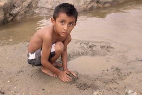 Boy is playing near the river