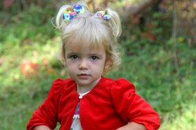 little girl with ponytails and in a red dress