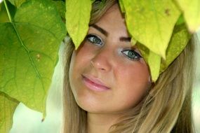 photo of a girl among green leaves
