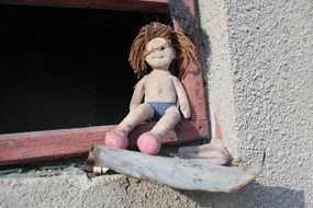 old doll on the window