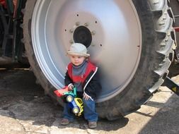 small child playing at the big machine wheel