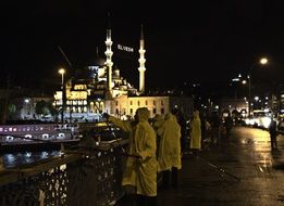 fishermen in yellow raincoats on a bridge