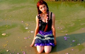 girl with flowers in her hair on a background of lake