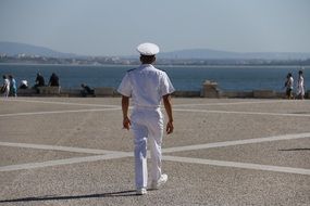 back view of a sailor in a white uniform on the background of the Tagus river