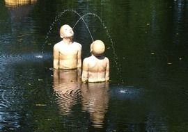 sculptures of children in the pond