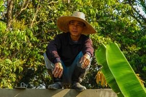 The Thai is pensively sitting on the wall