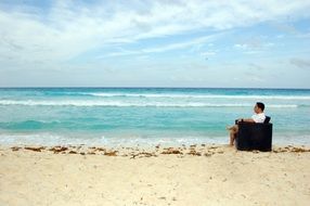 a young man in a chair on the beach