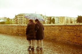 elderly couple of men walking in the rain