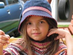 cute child girl in blue hat looking straight