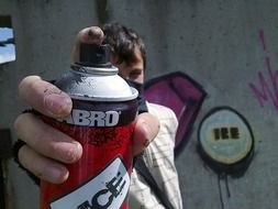 man is painting graffiti in the street