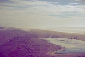 The Pacific Ocean beach with tracks in the sand