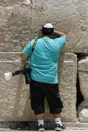 Back view of a man praying at the Western Wall (Wailing Wall)