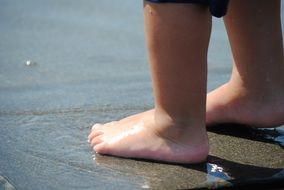 feet of a child playing in the water