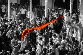 splash of yellow holi water above crowd at nandgaon temple, india, barsana