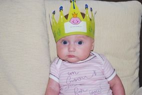 baby lies with a crown on his head