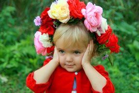 Beauty of thw little girl with a wreath of roses on her head