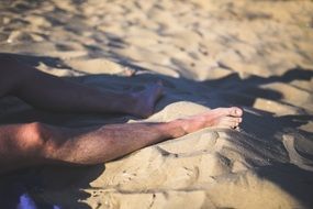 man leg in beach sand