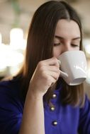 girl with a white cup in a cafe