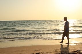 man on the beach against the setting sun