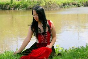 girl in a red dress by the lake