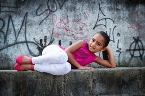 cute lindan child girl posing on stone wall